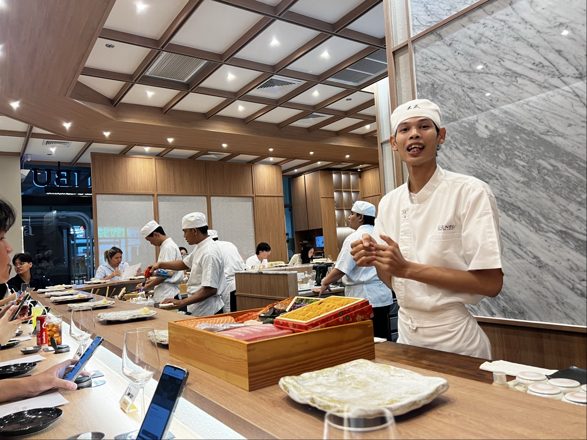 玄武のカウンターで食材について説明する寿司職人