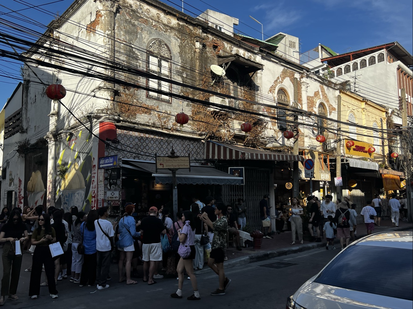 ソンワットロードの古い建物と飲食店の前に集まる人々
