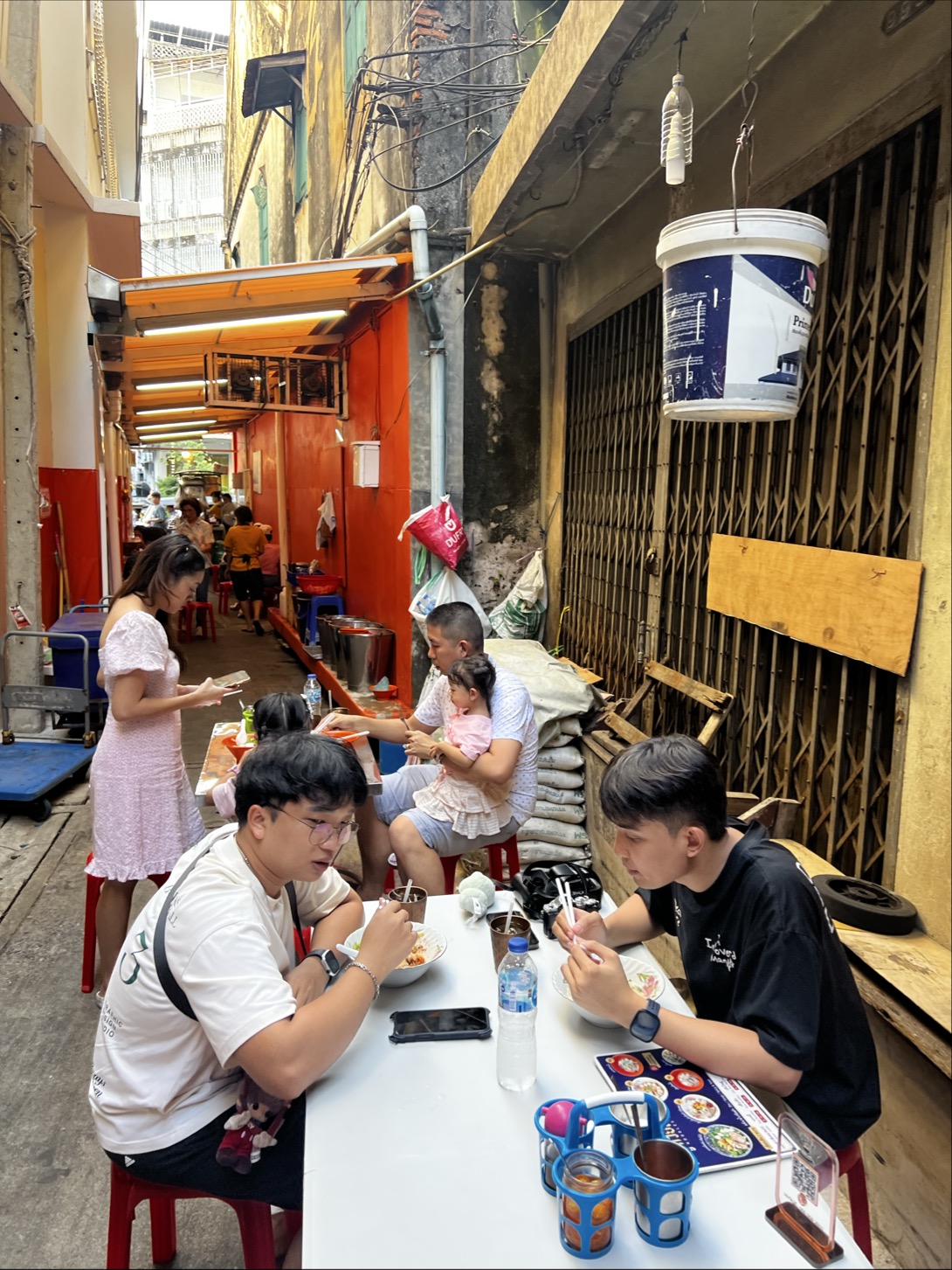 ソンワットロード周辺の細い路地で食事を楽しむ人々